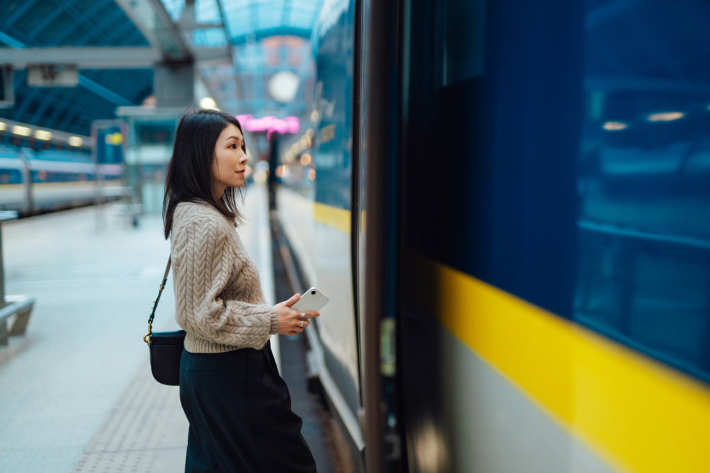 young businesswoman on business trip boarding train at railway station