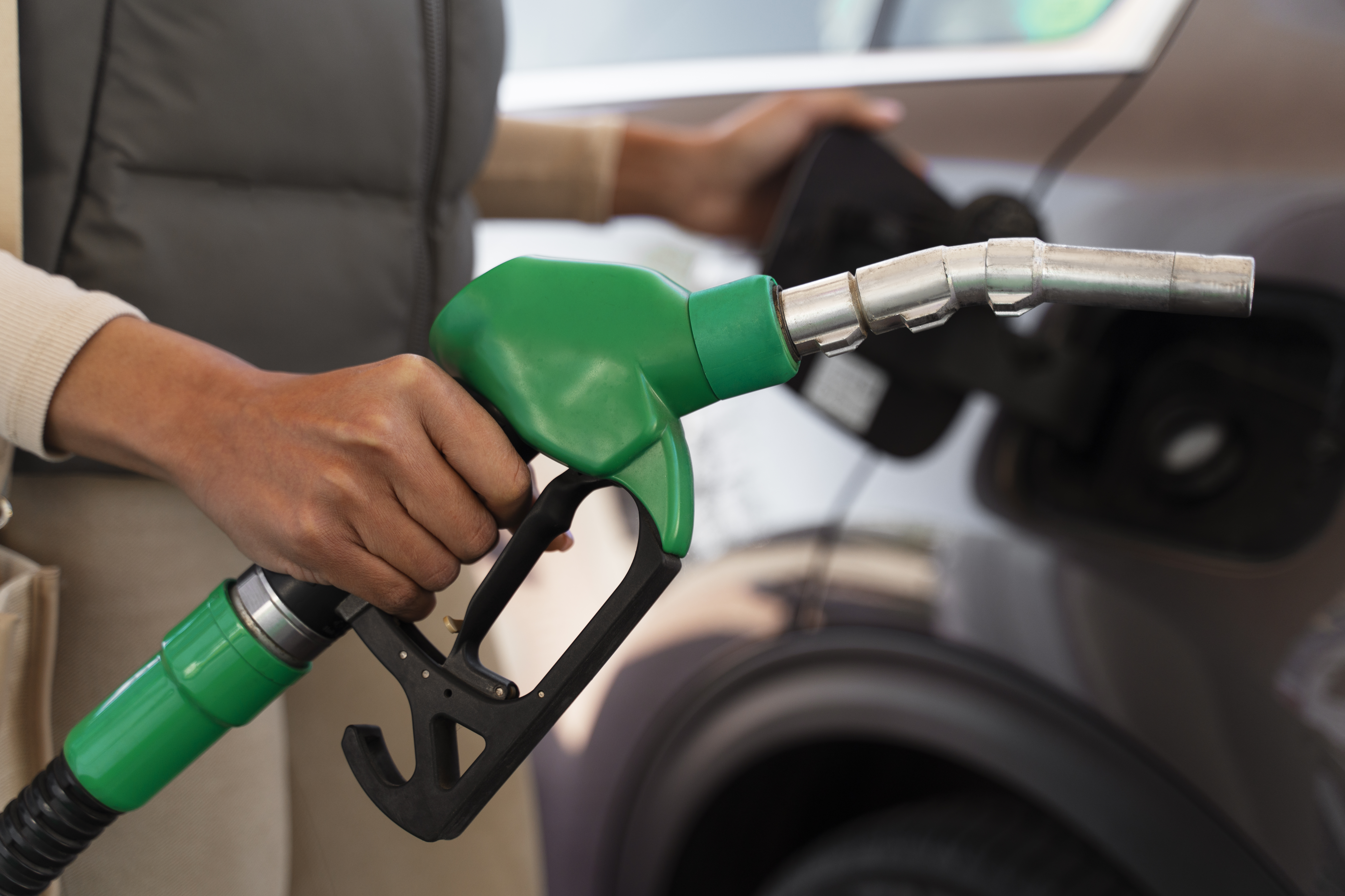 une jeune femme profite de sa prime carburant en station